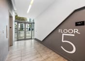 Thumbnail 13 of 66 - a large hallway with a large floor number on the wall and a glass door in the background