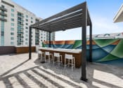 Thumbnail 33 of 66 - a patio with a bar and a mural on the side of a building