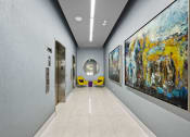 Thumbnail 10 of 66 - the hallway of a building with paintings on the wall and doors