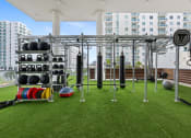 Thumbnail 30 of 66 - a gym on the roof of a building with weights and other equipment