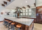Thumbnail 17 of 28 - A modern kitchen with a large island and wooden cabinets.