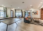 Thumbnail 15 of 28 - A ping pong table is in the middle of a living room.
