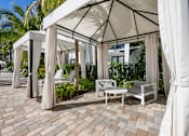 Thumbnail 18 of 47 - A patio with a white canopy and chairs.