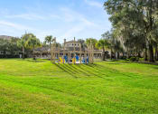 Thumbnail 65 of 67 - a large lawn with a playground and a mansion in the background