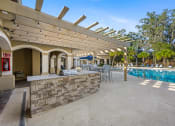 Thumbnail 57 of 67 - the pool area has a bar and a swimming pool with tables and chairs