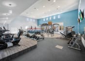 Thumbnail 43 of 67 - a gym with cardio equipment and weights on a wooden floor