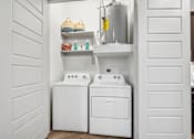 Thumbnail 12 of 34 - A white laundry room with a washer and dryer.