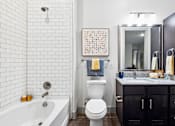 Thumbnail 9 of 34 - A bathroom with a white tub, toilet, and sink.