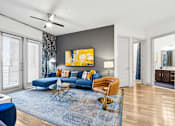 Thumbnail 1 of 34 - A living room with a blue couch and a yellow chair.
