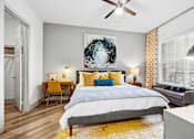Thumbnail 33 of 34 - A bedroom with a bed, a chair, a painting, and a ceiling fan.