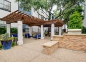 Thumbnail 24 of 32 - a patio with a stone wall and a pergola