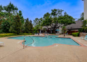 Thumbnail 22 of 32 - a swimming pool with trees and a building in the background
