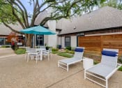 Thumbnail 21 of 32 - a patio with chairs and an umbrella in front of a house