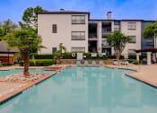 Thumbnail 19 of 32 - a swimming pool with a building in the background