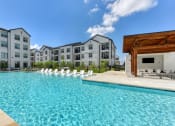 Thumbnail 3 of 16 - an outdoor swimming pool with apartments in the background