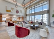 Thumbnail 2 of 16 - a living room with couches and chairs and large windows