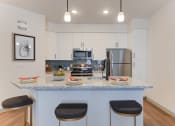 Thumbnail 8 of 16 - a kitchen with a granite counter top with three stools