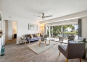 Thumbnail 33 of 41 - a living room with couches and chairs and sliding glass doors to a patio