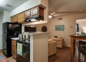 Thumbnail 2 of 8 - a kitchen and living room with a black refrigerator and stove