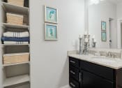 Thumbnail 25 of 29 - a bathroom with a sink and a mirror and a closet