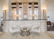 Thumbnail 3 of 29 - a lobby with two white chairs and a reception desk