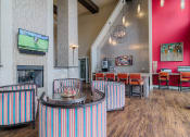 Thumbnail 4 of 29 - a clubhouse with a fireplace and tables and chairs
