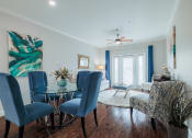 Thumbnail 21 of 29 - a living room with a glass dining room table with blue chairs