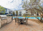 Thumbnail 17 of 29 - a patio with a table and chairs next to a swimming pool