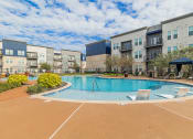 Thumbnail 14 of 29 - a swimming pool at an apartment complex with chairs around it