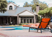 Thumbnail 23 of 32 - a pool chair in front of a house with a swimming pool