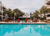 Thumbnail 24 of 32 - the residence apartment pool with chairs and buildings in the background