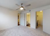 Thumbnail 15 of 32 - an empty living room with a ceiling fan and a door to a bathroom