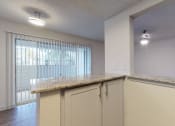 Thumbnail 14 of 32 - a kitchen with a counter top and a door to a living room