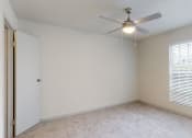 Thumbnail 18 of 32 - an empty bedroom with a ceiling fan and large windows