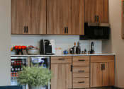 Thumbnail 28 of 32 - a kitchen with wooden cabinets and a black microwave