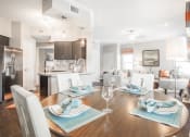 Thumbnail 5 of 19 - a living room and dining room with a table and chairs