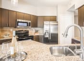 Thumbnail 2 of 19 - a modern kitchen with stainless steel appliances and marble counter tops