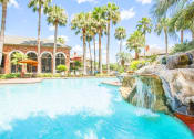 Thumbnail 14 of 19 - a large swimming pool with a waterfall and palm trees
