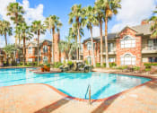 Thumbnail 13 of 19 - a large swimming pool in front of a building with palm trees
