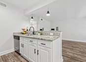 Thumbnail 4 of 38 - A kitchen with white cabinets and a granite countertop.