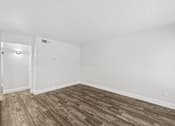 Thumbnail 8 of 38 - A room with a wooden floor and white walls.
