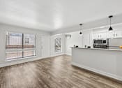Thumbnail 3 of 38 - A kitchen with a white counter and wooden floors.