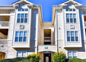 Thumbnail 16 of 29 - an apartment building with white siding and a clear blue sky