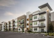 Thumbnail 27 of 45 - an exterior view of an apartment complex with a parking lot
