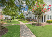 Thumbnail 37 of 39 - a walkway between two apartment buildings with trees and grass