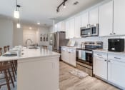Thumbnail 1 of 65 - a large kitchen with white cabinets and stainless steel appliances