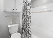 Thumbnail 9 of 32 - a bathroom with a shower curtain and a toilet