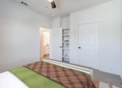 Thumbnail 18 of 65 - a bedroom with a bed and a closet and a door to a bathroom
