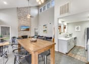 Thumbnail 14 of 26 - a dining area with a wooden table and chairs and a kitchen in the background
