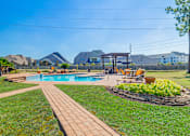 Thumbnail 50 of 61 - A backyard with a pool and a patio area.